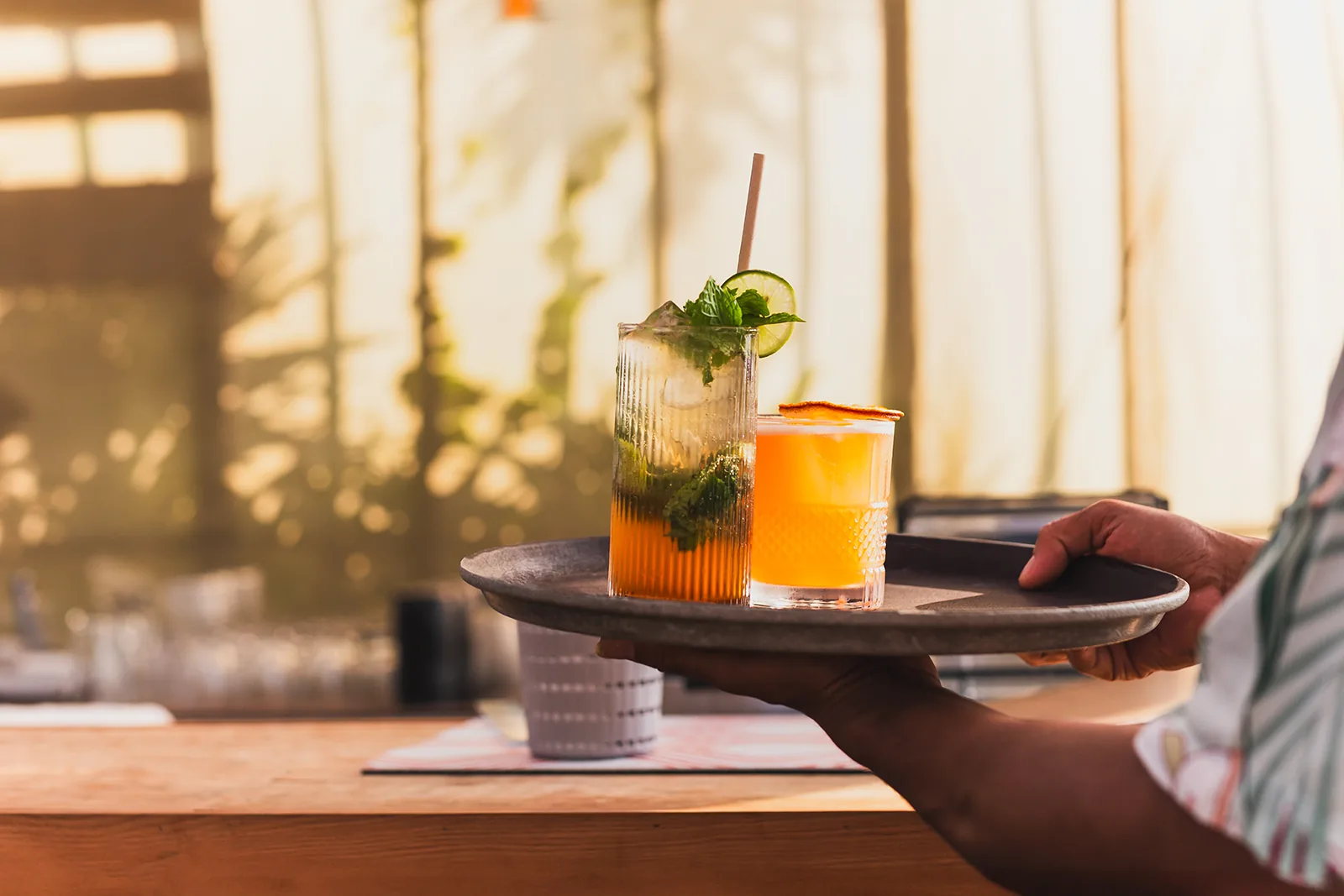 Due cocktail serviti su un vassoio in luce naturale