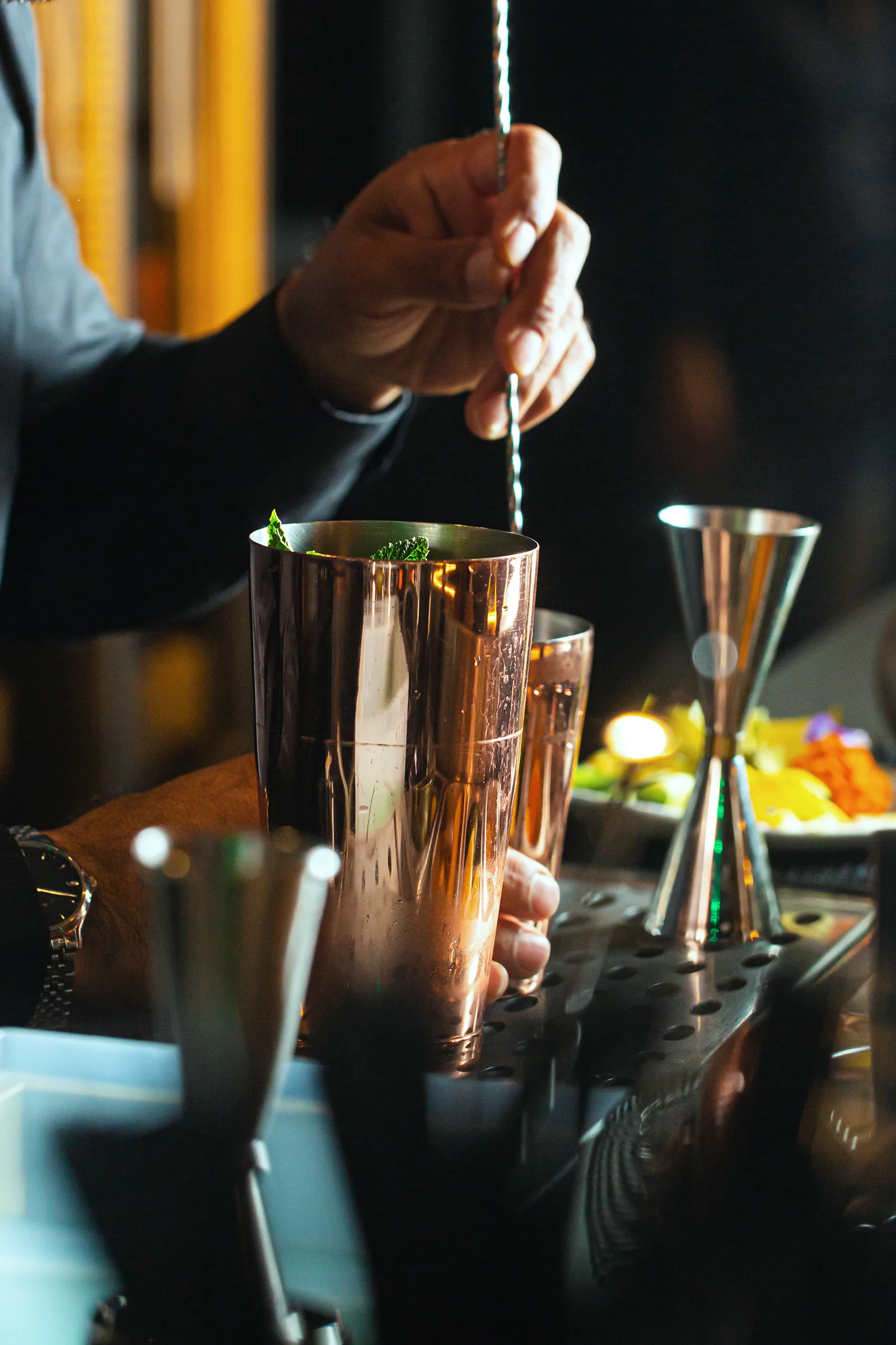 Miscelazione di un cocktail con strumenti da bar in rame