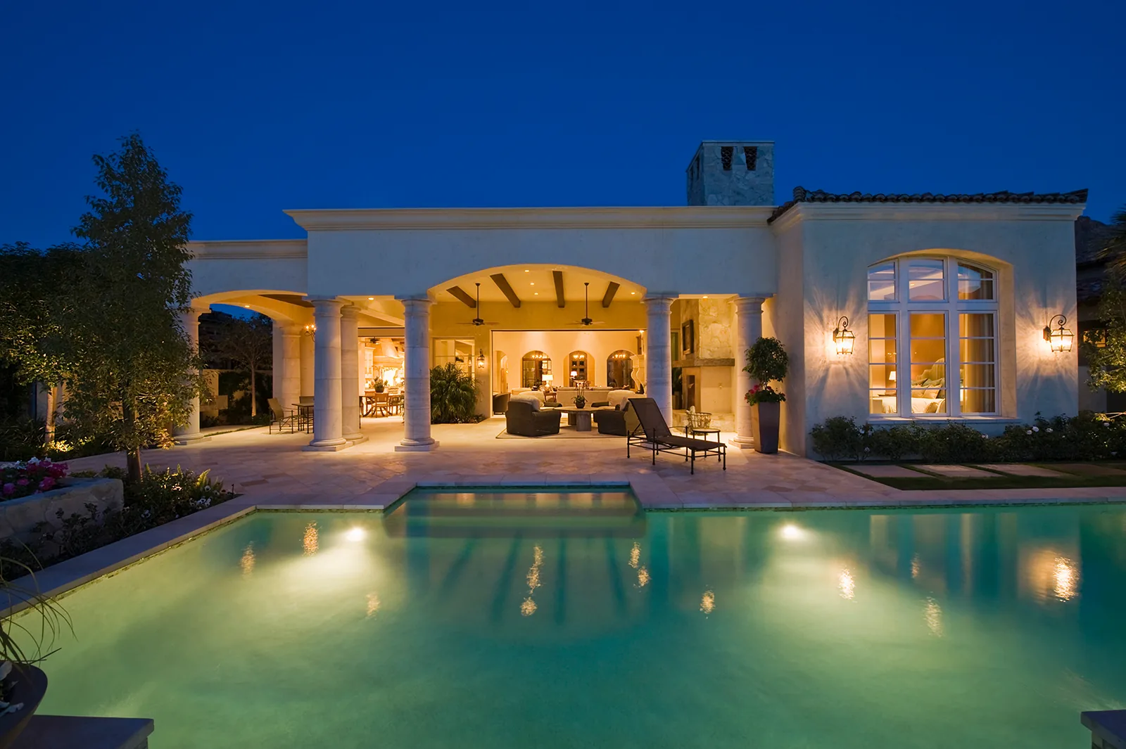 Villa con porticato e piscina illuminata la sera